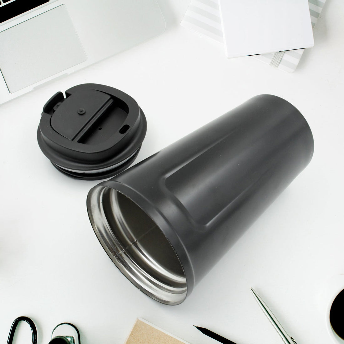 Stainless steel and plastic travel mug with vacuum insulation.